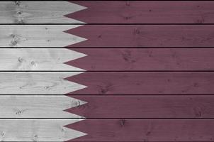 bandeira do qatar retratada em cores de tinta brilhante na parede de madeira velha. banner texturizado em fundo áspero foto