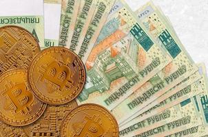Notas de 50 rublos bielorrussos e bitcoins dourados. conceito de investimento em criptomoeda. mineração ou negociação de criptomoedas foto
