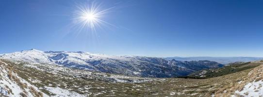 vista panorâmica de tirar o fôlego da serra nevada em granada, espanha, com sol estrelado foto