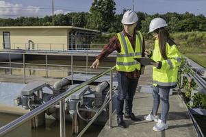 engenheiros ambientais trabalham em estações de tratamento de águas residuais, engenharia de abastecimento de água trabalhando em usinas de reciclagem de água para reutilização, técnicos e engenheiros discutem o trabalho em conjunto. foto