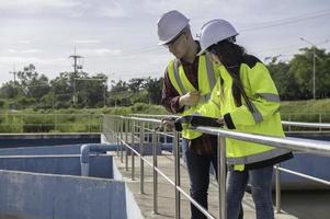 engenheiros ambientais trabalham em estações de tratamento de águas residuais, engenharia de abastecimento de água trabalhando em usinas de reciclagem de água para reutilização, técnicos e engenheiros discutem o trabalho em conjunto. foto