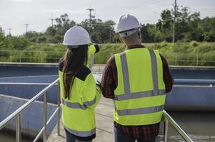 engenheiros ambientais trabalham em estações de tratamento de águas residuais, engenharia de abastecimento de água trabalhando em usinas de reciclagem de água para reutilização, técnicos e engenheiros discutem o trabalho em conjunto. foto