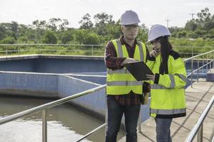 engenheiros ambientais trabalham em estações de tratamento de águas residuais, engenharia de abastecimento de água trabalhando em usinas de reciclagem de água para reutilização, técnicos e engenheiros discutem o trabalho em conjunto. foto