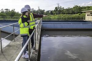 engenheiros ambientais trabalham em estações de tratamento de águas residuais, engenharia de abastecimento de água trabalhando em usinas de reciclagem de água para reutilização, técnicos e engenheiros discutem o trabalho em conjunto. foto