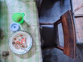 a mesa de jantar está uma bagunça. uma mesa de jantar bagunçada com pratos usados e cheia de restos de comida que não foram limpos. Vida real. fim de ano foto