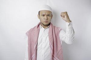 jovem muçulmano asiático se sentindo sério e focado olhando para a câmera enquanto levanta a mão foto