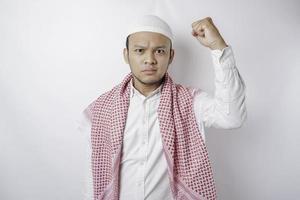 jovem muçulmano asiático se sentindo sério e focado olhando para a câmera enquanto levanta a mão foto