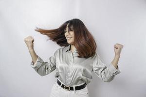 uma jovem mulher asiática com uma expressão de sucesso feliz vestindo camisa verde sálvia isolada por fundo branco foto