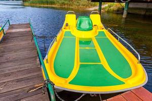 pedalinhos ou pedalinhos estação de catamarãs. bicicletas de água amarela trancadas no cais de doca do lago marina em dia ensolarado de verão. atividade de lazer de verão ao ar livre. foto