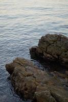 pedras na praia, águas calmas foto
