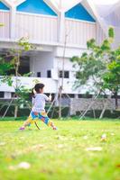 garota de retrato garoto exercitando na grama verde no verão ou primavera. criança feliz brincando com a natureza. crianças com 4 anos de idade. imagem vertical. espaço vazio. vista traseira traseira. foto