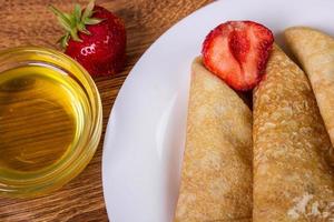 pilha de crepes com calda de morango e mel foto