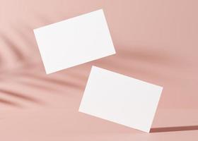 cartões de visita brancos em branco com sombras de plantas no fundo rosa. maquete natural para identidade de marca. duas cartas para mostrar os dois lados. modelo para designer gráfico. renderização 3D. foto