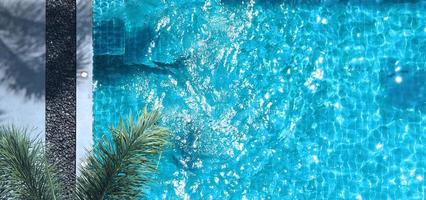 piscina de água azul no verão e camas de praia brancas e ângulo de visão superior. foto