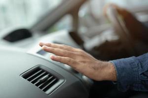closeup do motorista de mão verificando o ajuste do ar do condicionamento do sistema de refrigeração com fluxo de ar frio no carro. deixe espaço para escrever o texto. foto