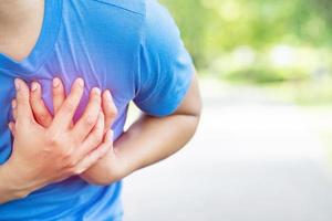 jogging correndo atleta homem com dor no peito durante o exercício - ataque cardíaco ao ar livre. ou exercício pesado faz com que o corpo sofra doenças cardíacas. pode causar risco de vida. conceito de cuidados de saúde. foto