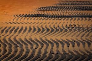 padrões na areia da praia foto