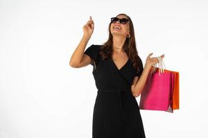 jovem mulher bonita segurando a sacola de compras no fundo branco isolado foto