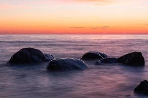 pedras na costa do mar báltico ao pôr do sol
