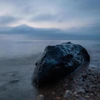 pedras na costa do mar báltico ao pôr do sol foto