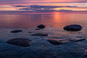 pedras na costa do mar báltico ao pôr do sol