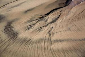 padrões na areia da praia foto