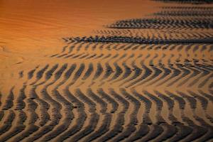 padrões na areia da praia foto