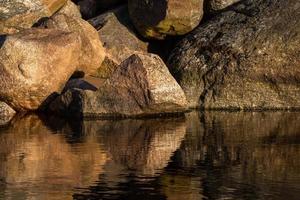 costa do mar báltico com seixos e gelo ao pôr do sol foto