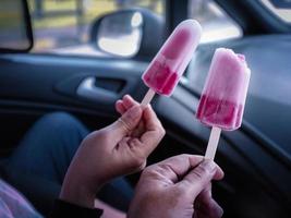um casal tomando sorvete de morango em um carro foto