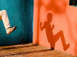 um menino brincando com luz e sombra foto