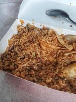 ainda sobra muito arroz frito em uma caixa de papelão. foto