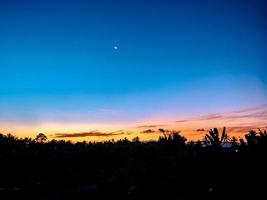 nascer do sol de manhã em uma aldeia no meio de campos de arroz foto