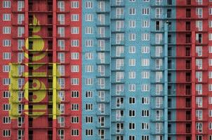 bandeira da mongólia retratada em cores de tinta em prédio residencial de vários andares em construção. banner texturizado no fundo da parede de tijolos foto