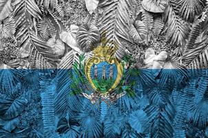 bandeira de san marino retratada em muitas folhas de palmeiras monstera. pano de fundo na moda foto