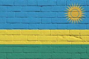 bandeira de ruanda retratada em cores de tinta na parede de tijolos antigos. banner texturizado em fundo de alvenaria de parede de tijolo grande foto