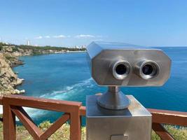 telescópio de binóculos brancos de viagem no deck de observação para atrações turísticas do mar foto