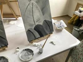 estúdio de arte com mesa e equipamento de pintura. cavalete de desenho no fundo foto