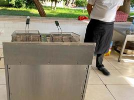 fritadeira de metal para cozinhar batatas fritas na cozinha em um restaurante de fast food foto