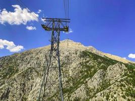 teleférico na montanha. cabos enormes e grossos para a passagem de turistas ao longo da altura. linha de energia fornece a estrada com energia foto