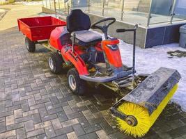 equipamentos de construção no local. construção de casas. limpando o local de trabalho com um carro especial com uma enorme escova para limpeza de asfalto. máquina de controle do motorista foto