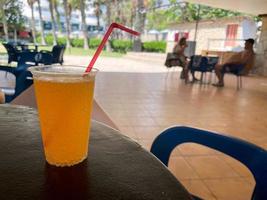 limão e suco de laranja na mesa de madeira, foco seletivo. bebidas frescas de verão. limonada gelada, suco de laranja e aguardente em copos na mesa ao ar livre. coquetel alcoólico refrescante. foto