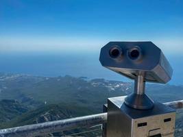 binóculos estacionários na plataforma de observação voltada para as montanhas foto