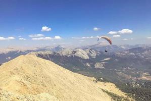 parapente ao ar livre, atividades ao ar livre, viagens em um país quente. viagem tendo como pano de fundo altas montanhas de plantas e areia foto