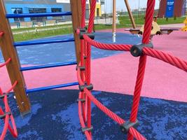 novo playground esportivo moderno para crianças com várias atividades, jogos, balanços, escorregadores, carrosséis e caixas de areia com uma cidade de corda no pátio ao ar livre foto