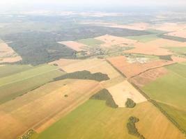 o avião voa a grande altura sobre um campo vazio. vista do terreno de cima. viagem aérea. os passageiros voam em um avião com belas vistas foto