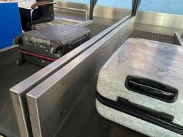 as malas viajam em uma esteira rolante no aeroporto. bagagem descarregada no transportador foto