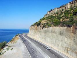 vista inspiradora do mar mediterrâneo e da estrada tendo como pano de fundo um penhasco na região de mahmutlar. Alanya, Turquia foto