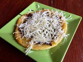 pão mariam com cobertura de chocolate e queijo, servido em prato verde foto