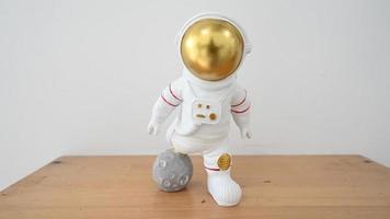 figura de brinquedo de plástico astronauta na mesa de madeira. minifiguras de brinquedo. vista de perto foto