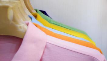 muitas camisas coloridas penduradas em um rack foto